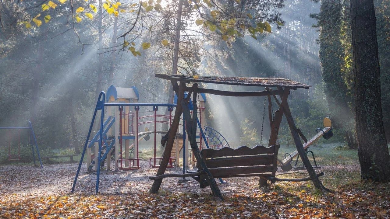 Children's playground with swings, slide and play structures in morning light