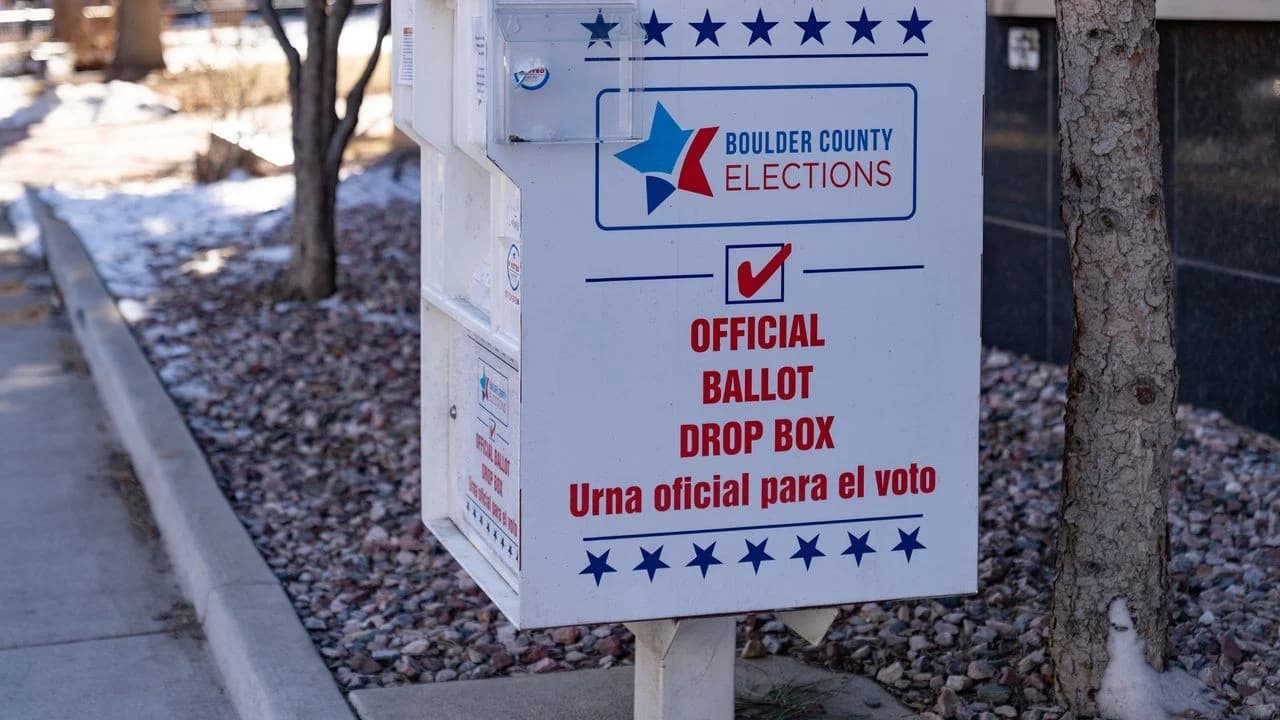 An official ballot drop box on a sidewalk; no people visible.