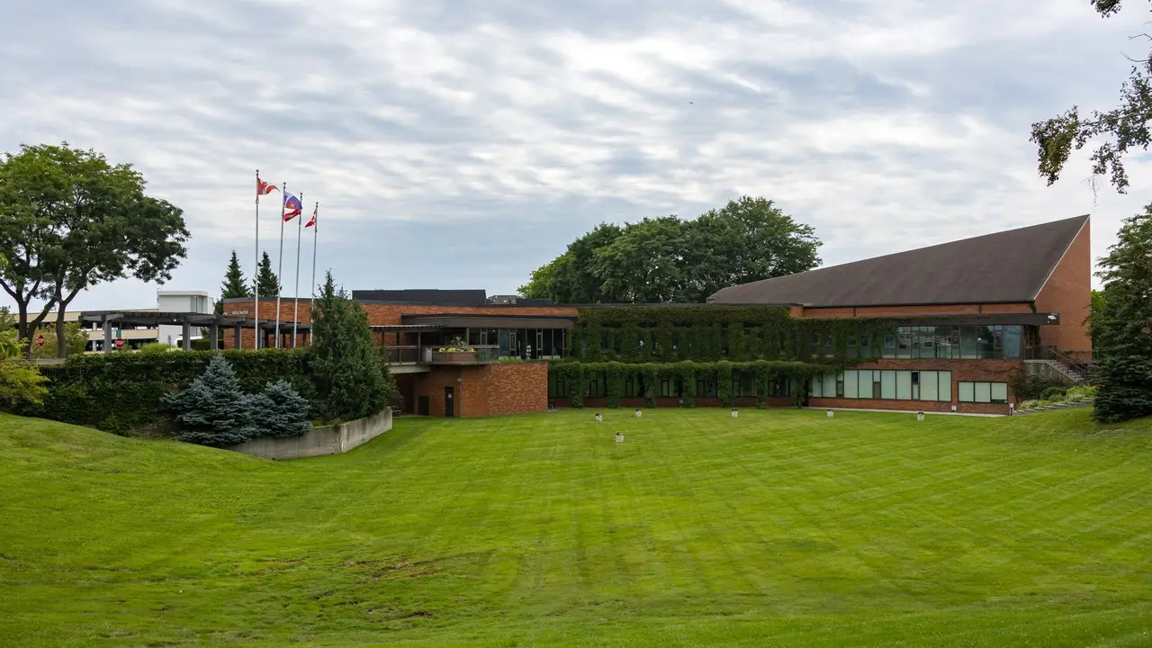 The Whitby Town Hall building on Rossland Road in Whitby, Ontario, photographed on a cloudy day; no people visible.