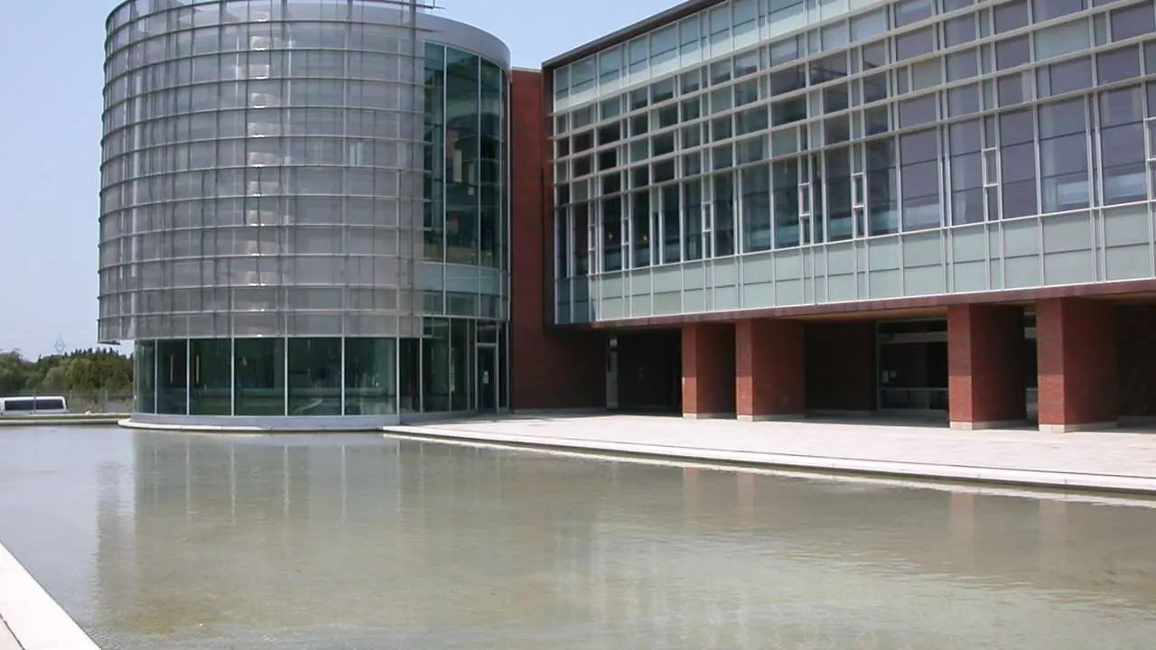 The University of Ontario Institute of Technology Library building, a modern glass and brick building across a reflecting pool; no people visible.