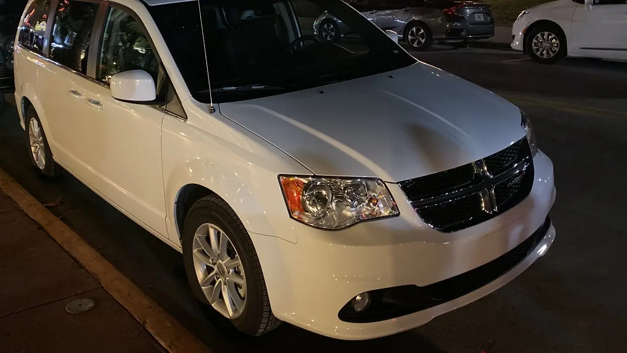 A white Dodge Grand Caravan minivan parked at night, the same model family as the vehicle named in the police report